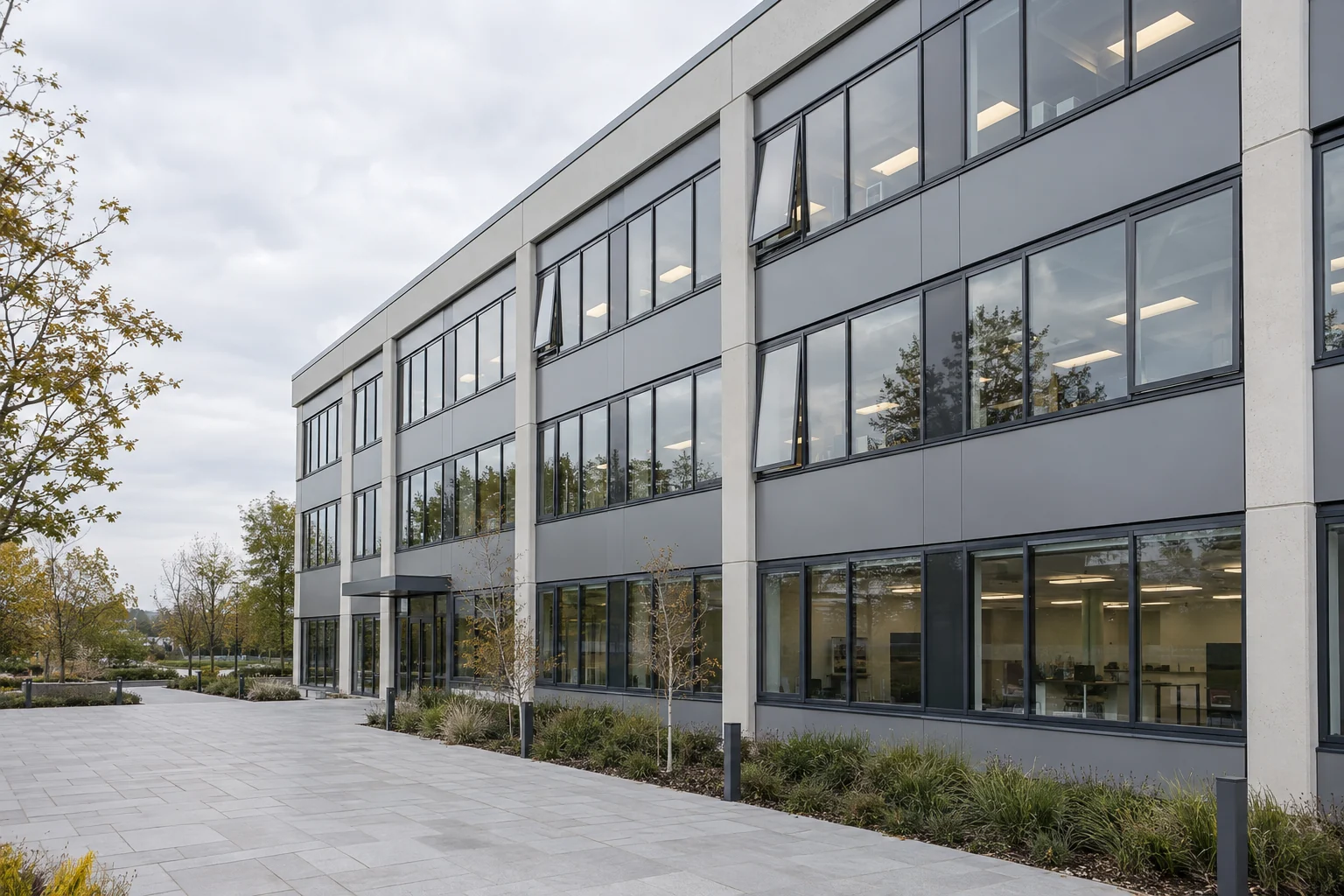 Illustrative three-storey office building with rows of aluminium windows and opening casements