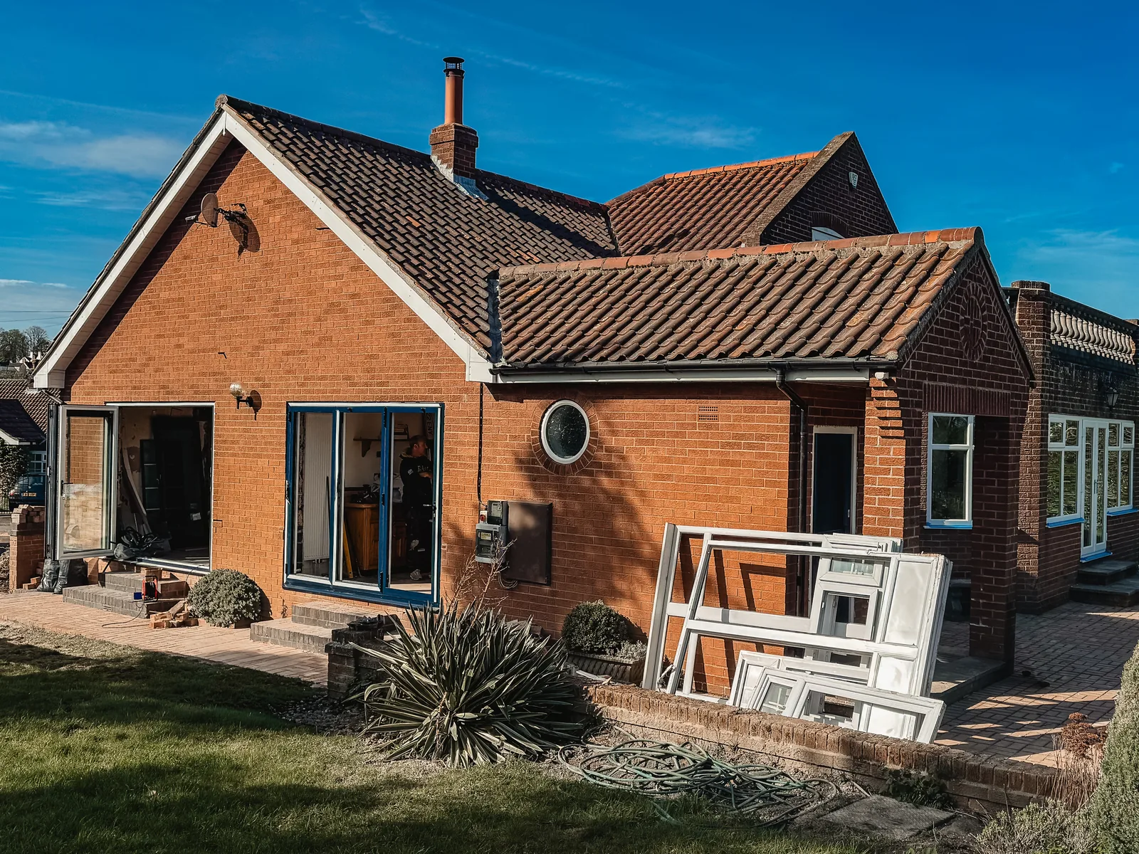 Domestic window replacement in progress, with original frames removed beside the garden-facing elevation