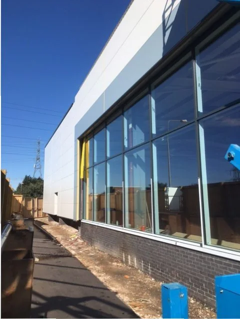 Aluminium-framed glazing beneath the cladding at Seager Retail, Cardiff
